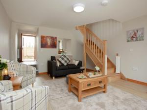 a living room with a couch and a staircase at Daisy Cottage - Uk31294 in Locking