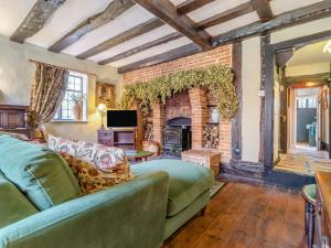 a living room with a couch and a fireplace at The Cottage in East Bergholt