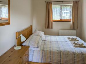 a bedroom with a bed and a table with a lamp at Briarwood - E4286 in Thorpe Market