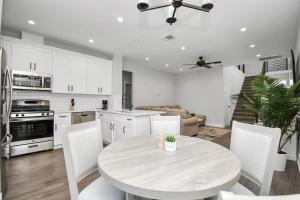 cocina blanca con mesa y armarios blancos en Family Friendly Spacious 3 Bedroom w Pool Table, en Four Corners