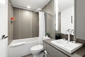 a white bathroom with a sink and a toilet at Stylish 1BR Condo in the heart of the Downtown TO in Toronto