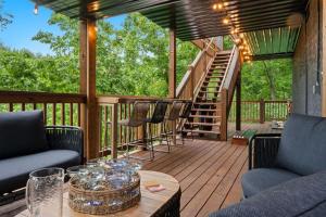 a deck with chairs and a table and a staircase at New Cabin Near Dollywood - Hot Tub-Stunning Views in Sevierville