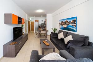 ein Wohnzimmer mit Sofa und Fernseher in der Unterkunft Endorfita Sonrisa - Canteras Beach in Las Palmas de Gran Canaria