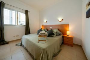 ein Schlafzimmer mit einem Bett mit einem Stuhl und einem Fenster in der Unterkunft Endorfita Sonrisa - Canteras Beach in Las Palmas de Gran Canaria