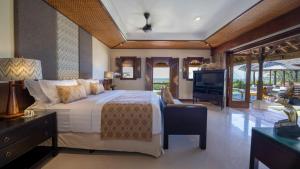 a bedroom with a large bed and a television at Villa Cemara in Sanur