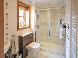 a bathroom with a shower and a toilet and a sink at Alfie's Abode in Ingoldmells