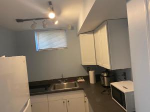 a small kitchen with a sink and a microwave at Guest Favorite in Upper Marlboro