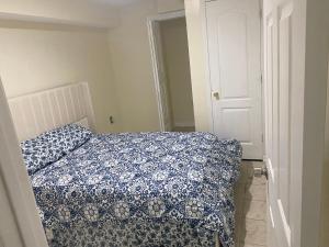 a bedroom with a bed with a blue and white comforter at Guest Favorite in Upper Marlboro