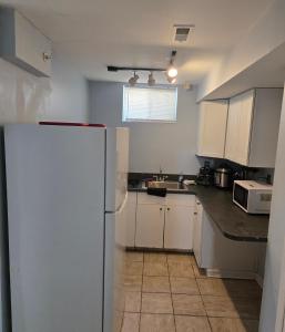 a kitchen with white cabinets and a refrigerator at Guest Favorite in Upper Marlboro