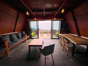 a living room with a wooden table and a couch at VIU Boutique Cabins in San Salvador