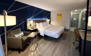 a hotel room with a large bed and a chair at Comfort Inn in Princeton