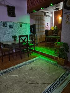 a room with a green floor and a table and chairs at Fayrouzat Elmandra Near the sea with garden view in Alexandria