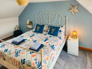Un dormitorio con una cama grande con paredes azules. en Seahaven Cottage, en Portknockie