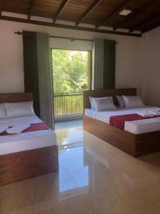 two beds sitting in a room with a window at Kandy Home Stay in Kandy