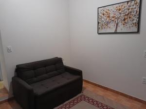 a living room with a couch and a painting on the wall at Pousada Baden Baden in Blumenau