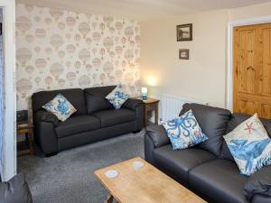 a living room with two couches and a table at Happy Days in Whitby