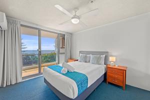 a bedroom with a bed and a large window at Northwind Beachfront Apartments in Mooloolaba +202 photos