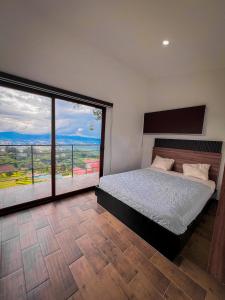 a bedroom with a bed and a large window at VIU Boutique Cabins in San Salvador +71 photos