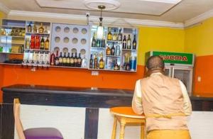 a man sitting at a table in a bar at Rikkies Place Hotel in Lagos +6 photos