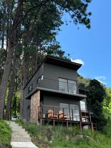 a house on the side of a hill with trees at VIU Boutique Cabins in San Salvador