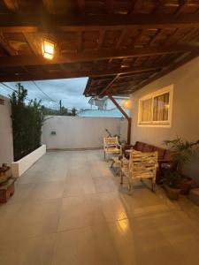 eine Terrasse mit 3 Holzstühlen und einem Tisch in der Unterkunft Bela e Aconchegante casa em Vargem Grande in Rio de Janeiro + 8 Fotos