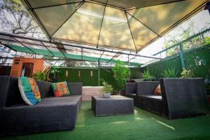 an outdoor patio with two couches and a roof at Casa en segundo piso con Sauna, Jacuzzi y Piscina in Santiago