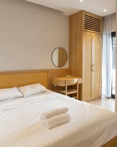 a bedroom with a bed with two towels on it at Sabi Room Ecopark view sông Hồng in Kim Quan