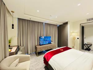 a hotel room with a bed and a flat screen tv at Taj Hotel Suites F-7 Islamabad in Islamabad