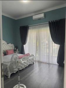 a bedroom with a bed and a large window at Nhà nguyên căn 3 phòng ngủ in Ấp Bình Hưng