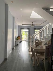 a hallway with a staircase with a table and chairs at Nhà nguyên căn 3 phòng ngủ in Ấp Bình Hưng
