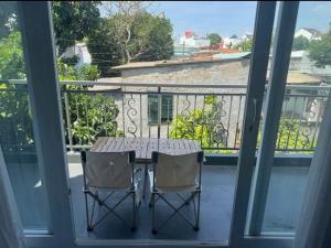 a table and two chairs on a balcony at Nhà nguyên căn 3 phòng ngủ in Ấp Bình Hưng +2 photos