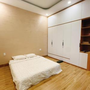 a bedroom with a bed and white cabinets at Shin's House Cozy & Green Space in Phu Quoc