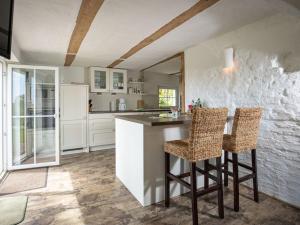 eine Küche mit Theke und zwei Barhockern in der Unterkunft Holiday home with 2 bedrooms in Buschvitz