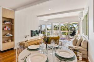 a living room with a table with plates on it at Seaviews Little Cove Beach Noosa 2BR 200m to beach in Noosa Heads