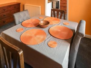 a table with orange plates and a bowl on it at 5 Rose Cottages in Sandhurst