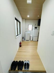Un grupo de zapatos sobre un piso de madera en una habitación. en モリアパートメント 203, en Tokio
