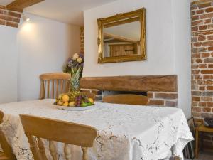 a table with a bowl of fruit and a mirror at Holme Cottage in Eastry