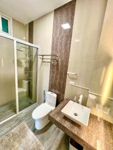 a bathroom with a toilet and a sink and a shower at Panika cozy rooms in Malaybalay +18 photos