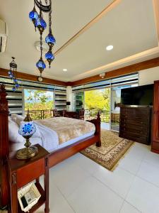 a bedroom with a large bed and a large window at Panika cozy rooms in Malaybalay