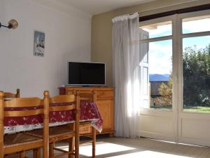 a living room with a television and a window at Appartement 3 pièces, plein sud, centre de Font-Romeu - FR-1-580-136 in Font-Romeu