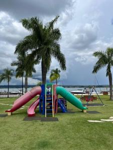 a playground with a slide in a park with palm trees at Life Resort, Trabalho e Lazer! in Brasilia