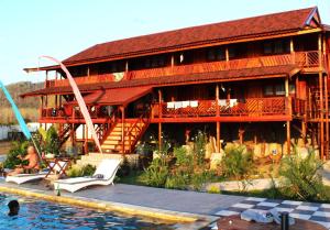 a large wooden house with a pool in front of it at Lakey Peak Haven in Huu