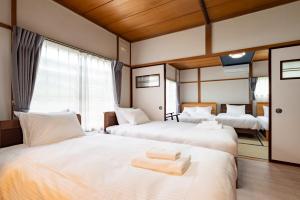 Una habitación de hotel con dos camas con toallas. en Hatsune 観光拠点 多人数向け 閑静な住宅街, en Otaru