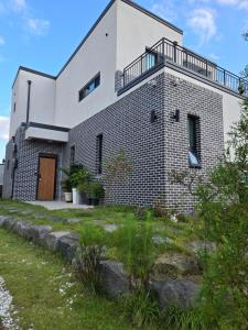 a brick house with a balcony on top of it at Daori Pension in Boryeong
