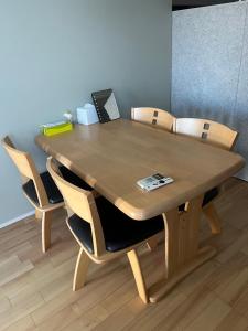 a wooden table with chairs in a room at 8108 yadoya in Ogori