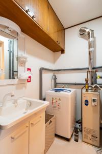 Un baño con lavabo y calentador de agua. en Hatsune 観光拠点 多人数向け 閑静な住宅街, en Otaru
