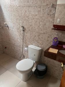 a bathroom with a toilet and a sink at Suíte completa em Parintins in Parintins