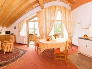 a kitchen and dining room with a table and chairs at Guesthouse Büchele in Hirschegg