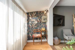 ein Flur mit einem Stuhl und einer Wand mit einer Tapete in der Unterkunft The Crooked Lady Cozy Bungalow near Downtown Calgary with Free Parking in Calgary