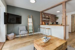 ein Wohnzimmer mit Tisch und Fernseher in der Unterkunft The Crooked Lady Cozy Bungalow near Downtown Calgary with Free Parking in Calgary